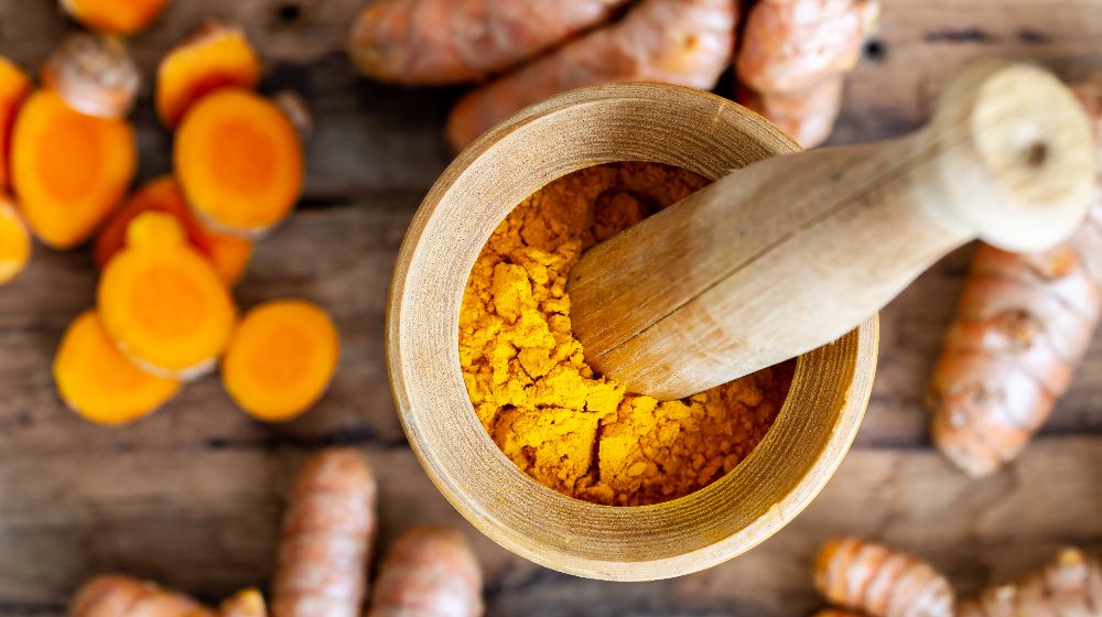 sliced curcumin, curcumin root on wooden background | The Science Behind the Use of Cucurmin for Healthy Aging