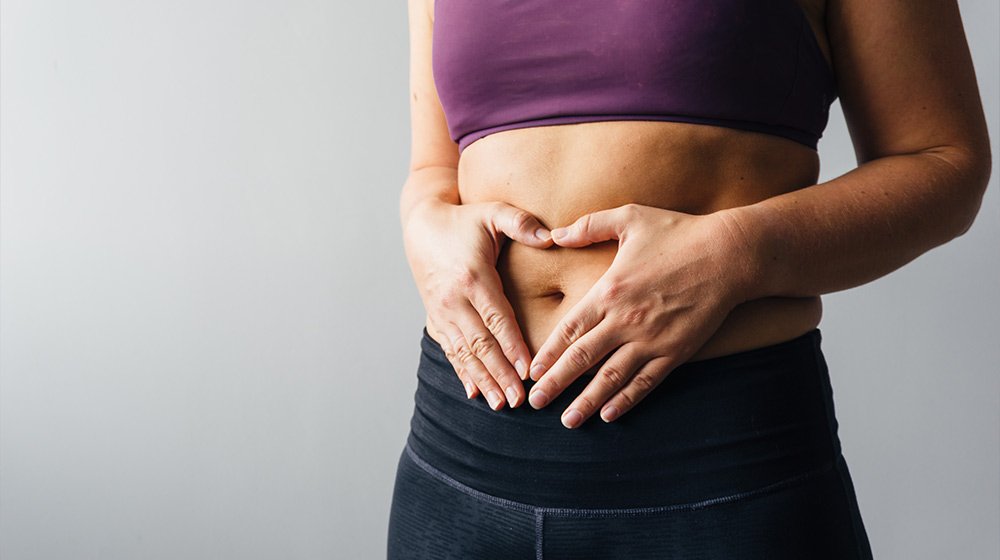 Close-up-of-hands-in-a-heart-on-stomach-5-Best-Anti-aging-Foods-for-Gut-Health-ss-feat | 5 Best Anti-aging Foods for Gut Health