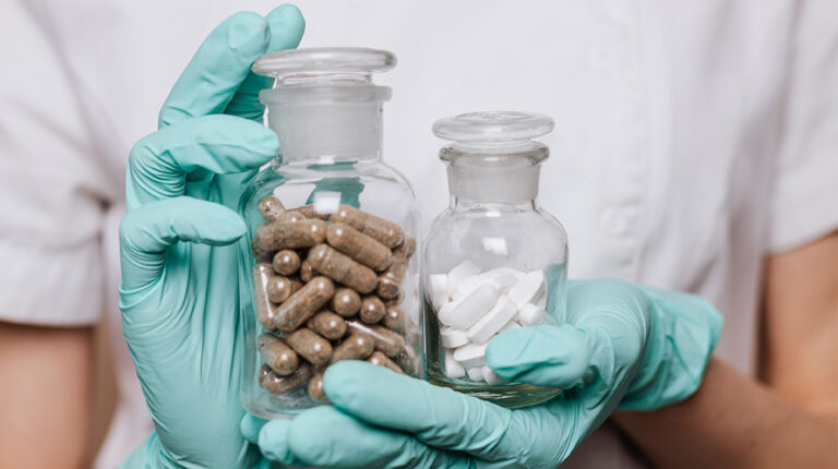 Woman-Holding-Two-Clear-Bottles-with-Medicines-BPC-157-Capsules-Enhance-Recovery-Without-Needles,-Making-an-Alternative-to-Injections-px-feat